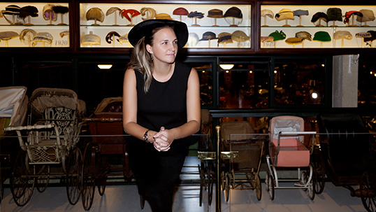 Yasemin Genç Uygur in front of her Hat Collection 